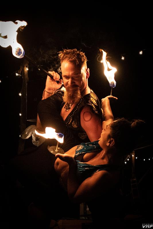 Radhika and John sharing an intimate theatrical fire moment