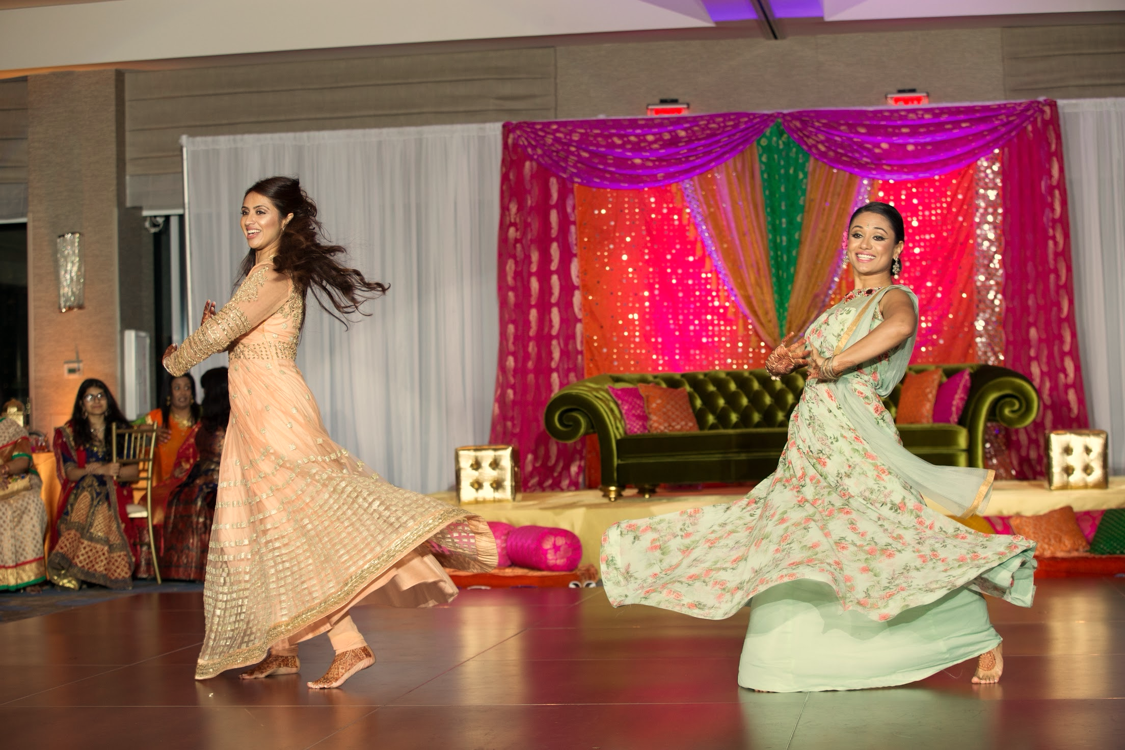 Two dancers performing in South Asian celebration attire